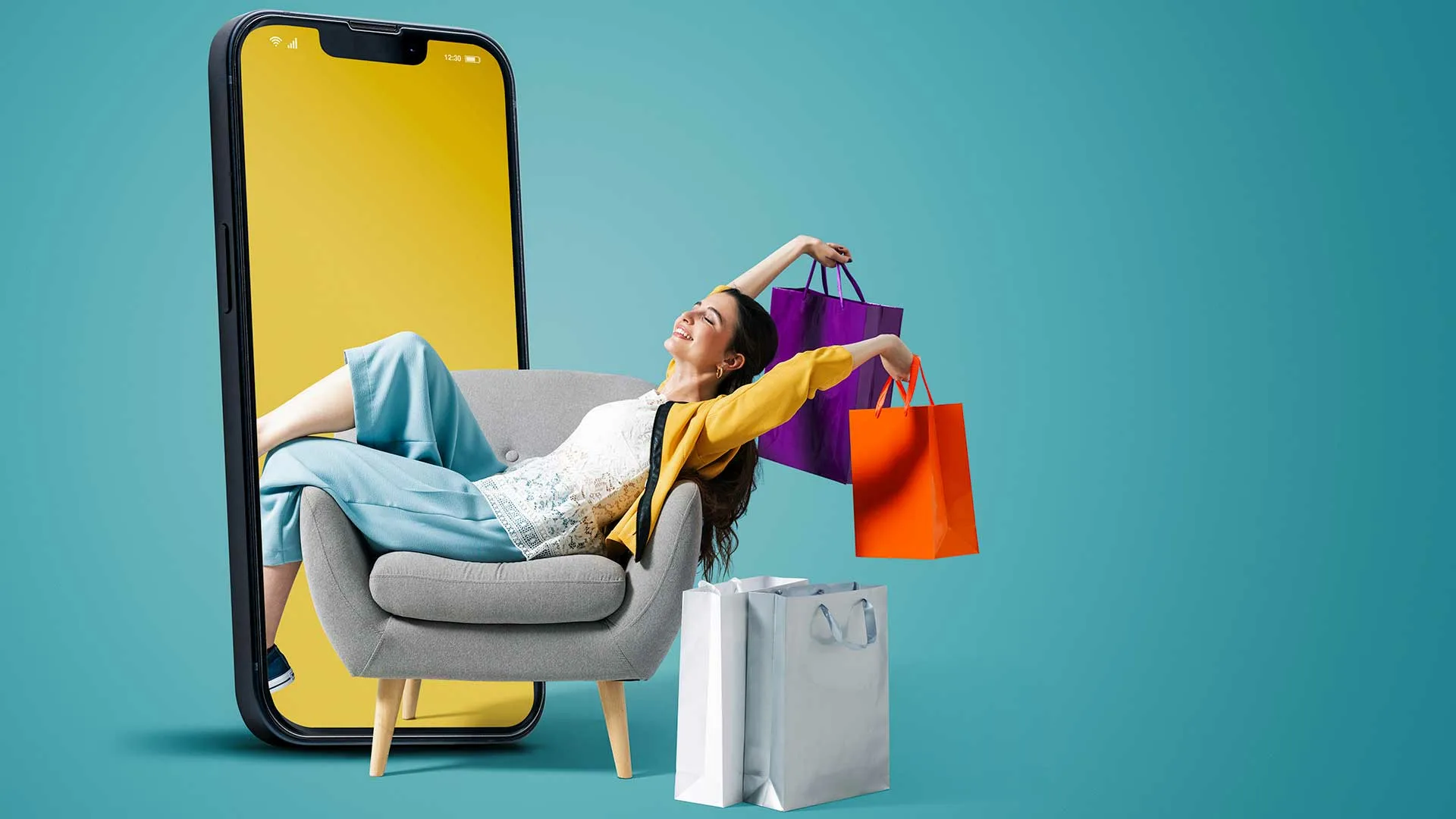 A happy woman holding shopping bags next to a giant iphone screen