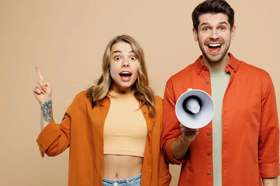 A man holding a megaphone next to a woman with her finger pointing up