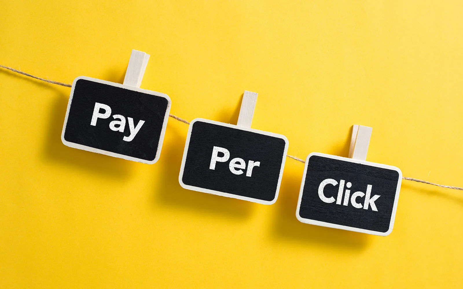 Three black block hanging form a string with the words Pay Per Click