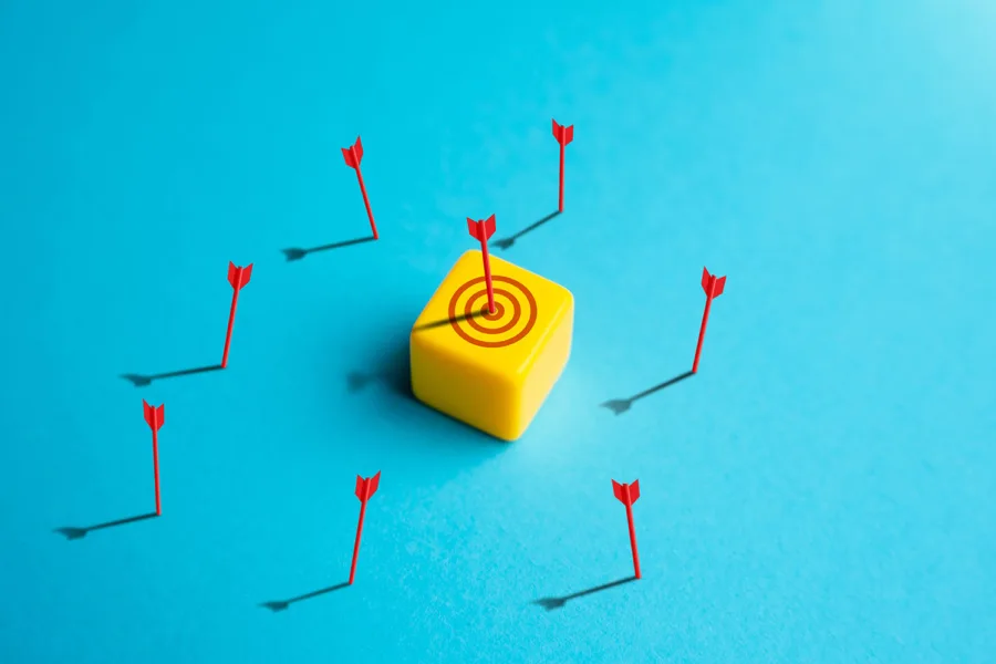 a yellow bullseye on a blue background surrounded by red arrows