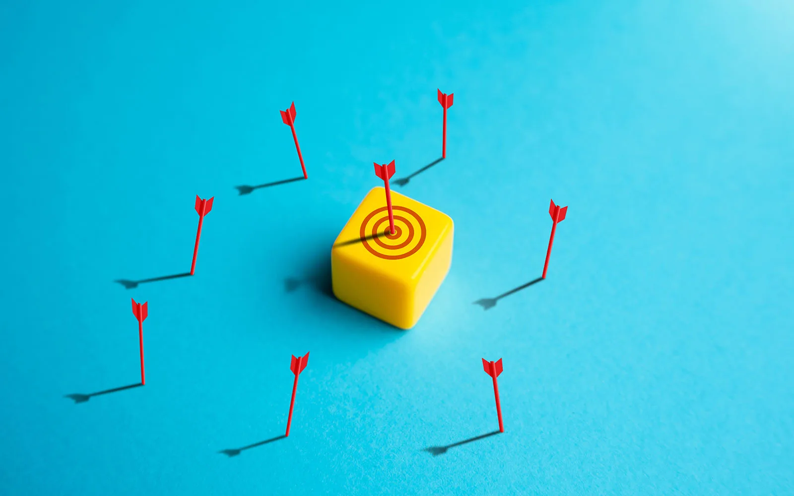 a yellow bullseye on a blue background surrounded by red arrows