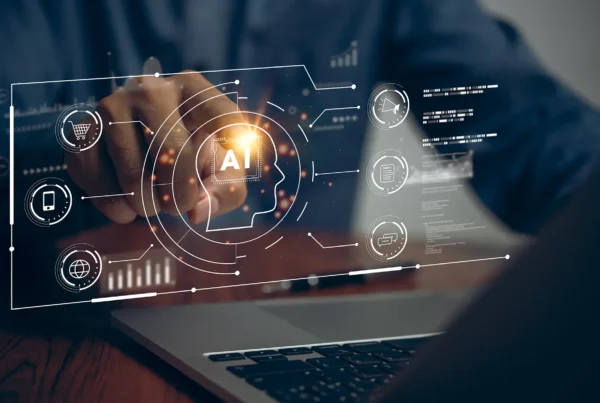 Man sitting in front of a laptop touching a virtual image of an eCommerce AI system floating over the keyboard