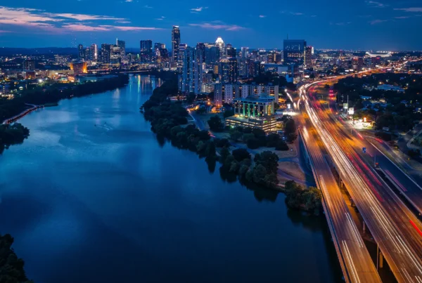 A view of the Austin, TX, skyline at night over Lady Bird Lake, near I-35
