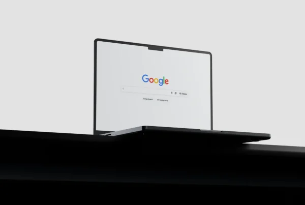 An open black laptop sitting on a desk displaying the Google search screen