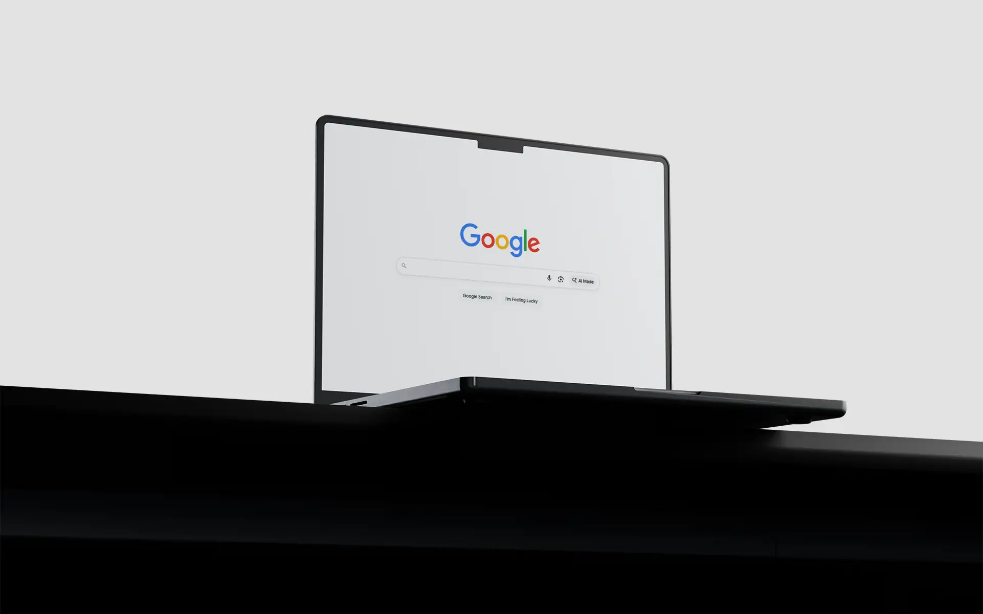 An open black laptop sitting on a desk displaying the Google search screen